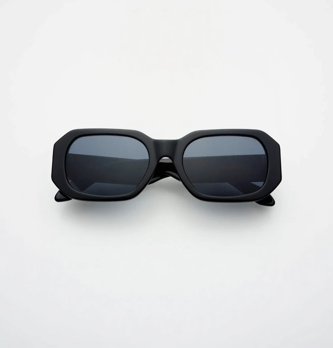 Black sunglasses with dark lenses on a white background